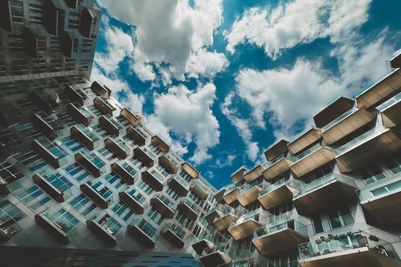 A modern apartment building with balconies against a bright blue sky