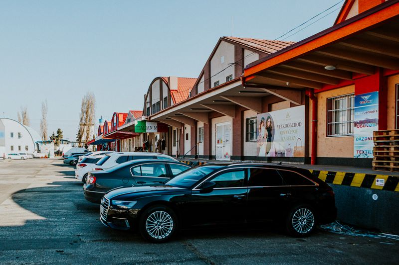 A neighborhood retail building with shops and a parking lot in front