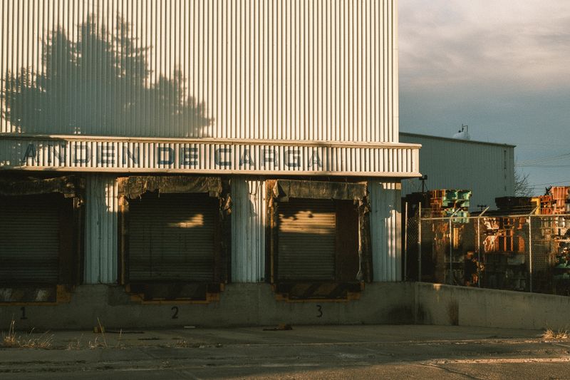 An industrial warehouse with loading docks in morning light
