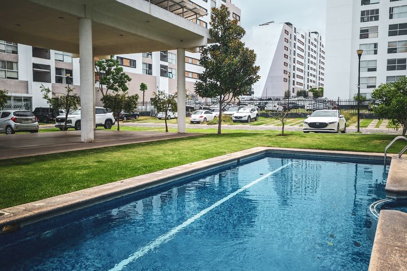 A modern residential complex seen from above, with a pool in the courtyard